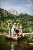 Children playing on a raft in a lake, Gossensass, Brenner, South Tyrol, Trentino-Alto Adige/Suedtirol, Italy