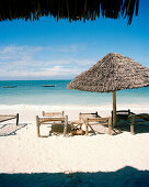 Sonnenschirme und traditionelle Sansibar Betten aus Kokosschnüren für Gäste, Strand des Blue Oyster Hotel, Jambiani, Südosten, Sansibar, Tansania, Ostafrika