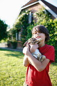 Junge mit Kaninchen im Arm, Haus Strauss, Bauernkate in Klein Thurow, Roggendorf, Mecklenburg-Vorpommern, Deutschland