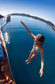 Girl jumping from sailing boat, lycian coast, Lycia, Mediterranean Sea, Turkey, Asia
