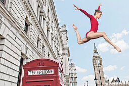 Gymnast leaping from telephone booth. Gymnast leaping from telephone booth