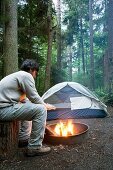 Man by campfire at South Whidbey State Park, Whidbey Island, Washington