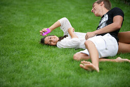 Lauging young couple lying in a meadow, Vienna, Austria