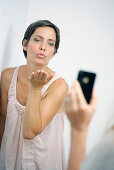 Frau wirft Kusshand in ein Handy, Wien, Österreich