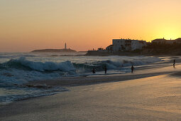 Menschen am Strand bei Sonnenuntergang, im Hintergrund das Cabo de Trafalgar, Los Canos de Meca, Andalusien, Spanien, Europa