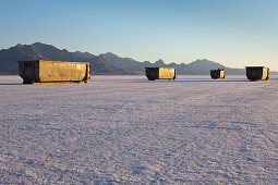 Large garbage  and recycling containers on Bonneville Salt Flats in  Speed Week, an annual amateur auto racing event. A row of four large containers for trash. Utah, USA., Bonneville Salt Flats in Speed Week