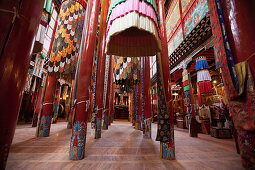 Derge Gonchen Gompa. The Sakya Monastery, being refurbished and rebuilt. Richly decorated pillars and fabric banners. Prayer Hall., Sichuan Tibet