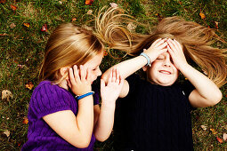 Two Young Girls Laying on Grass