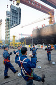 Shipyard workers doing morning exercises before shift, modular production at the largest shipyard in the world Hyundai Heavy Industries, HHI, in Ulsan, South Korea, Asia
