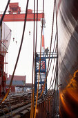 Chinesische Werftarbeiter betreten Frachter über Treppengerüst, Ouhua Werft in Zhoushan, Zhejiang Provinz, China