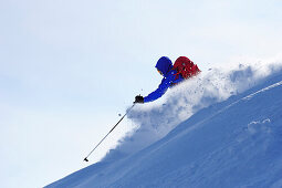 Young man downhill skiing from mount Sulzspitze, Tannheim Mountains, Allgaeu Alps, Tyrol, Austria