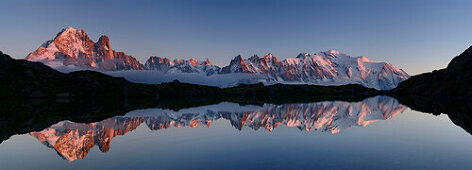 Panorama of Mont Blanc range reflecting in mountain lake, Mont Blanc range, Chamonix, Savoy, France