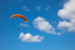 Paraglider in front of clouded sky