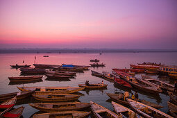 Boote liegen vor dem Dasaswamedh Ghat am Ufer des Fluss Ganges bei Tagesanbruch, Varanasi, Uttar Pradesh, Indien