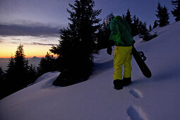 Snowboarder beim Aufstieg im Tiefschnee, Hahnenkamm, Tirol, Österreich