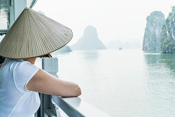 Woman on a wooden junk enjoying the view in Halong Bay, north of Vietnam, Asia