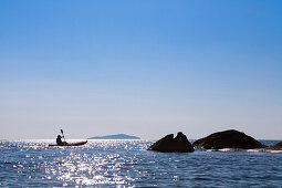 A man paddling in a canoe at Cape Maclear, Otters Point, Lake Malawi, Africa