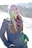 Junge Frau steht im Schneefall, Steiermark, Österreich