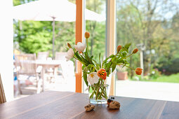 Tulpen in einer Vase am Tisch, Wohnzimmer mit dem Blick ins Garten, Frühling, Steiermark, Österreich