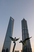 Angel sculptures in front of Shanghai World Financial Center and Jin Mao-Tower, Lujiazui Park, Pudong, Shanghai, China