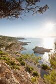 Coastal road leads to S'Illot chapel, view over Playa S'Illot beach, Alcudia peninsula, bay of Pollenca, Mallorca, Balearic Islands, Spain