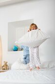 Four year old girl jumping on the bed