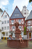 Children sitting around a fountain, old town of Diez on the river Lahn, Schloss Diez, Diez castle, Diez, Westerwald, Rhineland-Palatinate, Germany, Europe