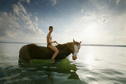 Mädchen auf einem Pferd im Starnberger See, Bayern, Deutschland