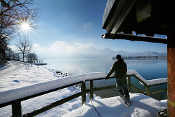 Man standing on snow-covered jetty at lake Kochel, Upper Bavaria, Germany