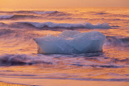 Icebergs in the waves in the glacial lake, Jokulsarlon in the morning light, East Iceland, Iceland