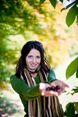 Junge Frau hält Kastanien in den Händen, Steiermark, Österreich