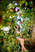 Young woman in an apple tree, Styria, Austria