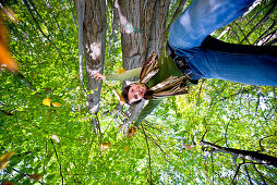 Young woman throwing autumn leaves in the air, Styria, Austria