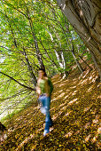 Junge Frau läuft durch einen Herbstwald, Steiermark, Österreich