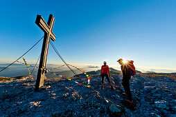 Hikers on summit of mount Hochschwab in sunset, Styria, Austria