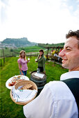 Zwei junge Frauen genießen lokale Spezialitäten in einem Weinberg, Riegersburg, Steiermark, Österreich