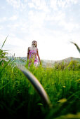 Young woman walking through high grass, Riegersburg, Styria, Austria
