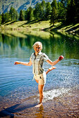 Young woman standing in lake Duisitzkar, Styria, Austria