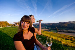 Zwei junge Frauen trinken Weißwein auf einem Weingut, Gamlitz, Steiermark, Österreich
