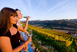 Zwei junge Frauen trinken Weißwein auf einem Weingut, Gamlitz, Steiermark, Österreich