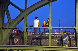 People sitting on the Hacker bridge in the evening, Munich, Bavaria, Germany