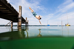 Junge springt in Starnberger See, Bayern, Deutschland