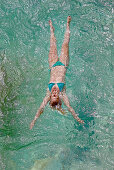 Junge Frau badet im Fluss Soca, Alpe-Adria-Trail, Tolmin, Slowenien