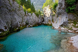 Young woman standing in the water of the river Soca, Alpe-Adria-Trail, Tolmin, Slovenia