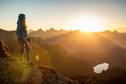 Hiker standing on rocky hilltop. Branderschrofen, Tegelberg