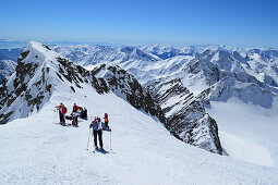 Group of persons back-country skiing standing in notch in front of the summit of Weisskugel, Weisskugel, Oetztal range, South Tyrol, Italy