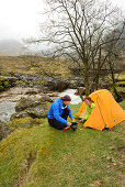 Paar kocht vor einem Zelt, Glen Etive, Buachaille Etive Mor, Highlands, Schottland, Großbritannien