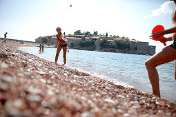 Couple playing beach ball at beach, Sveti Stefan, Budva, Montenegro