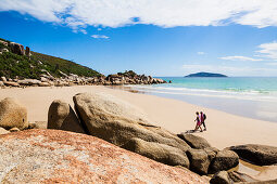 Two persons walking at beach of Fairy Cove, Wilsons Promontory, Victoria, Australia