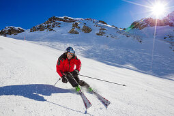 Skier downhill skiing from mount Parpaner Rothorn, Lenzerheide, Canton of Graubuenden, Switzerland